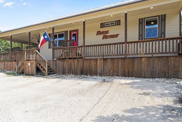 view of front of home with metal roof, a porch, and stairway