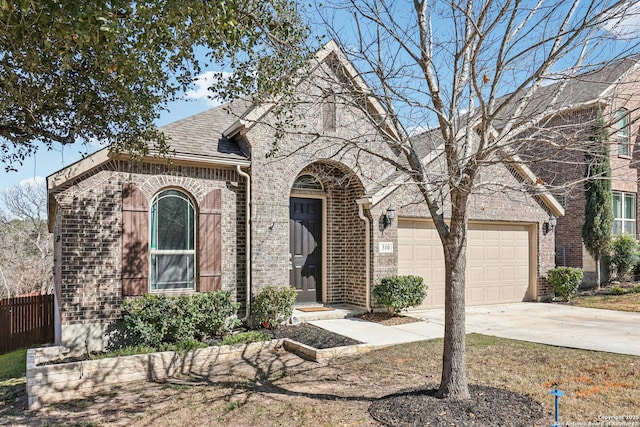 view of front of property featuring brick siding, a shingled roof, concrete driveway, an attached garage, and fence