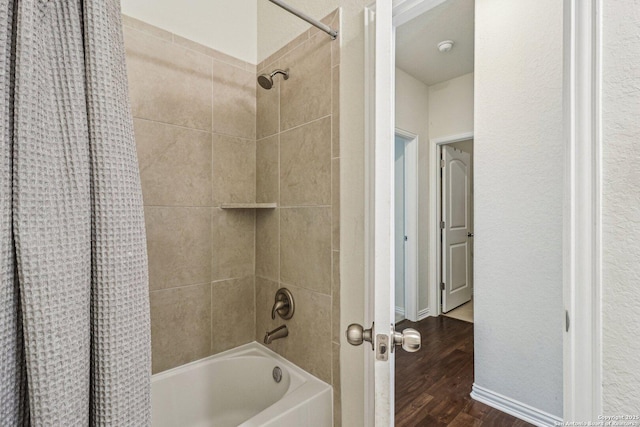 full bath with shower / tub combo and wood finished floors