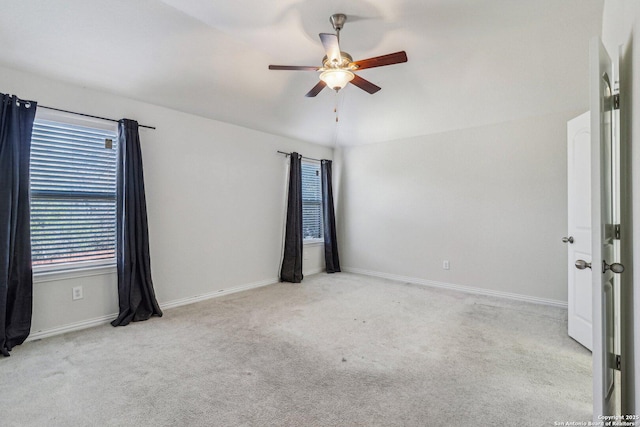 spare room featuring ceiling fan, baseboards, and light colored carpet