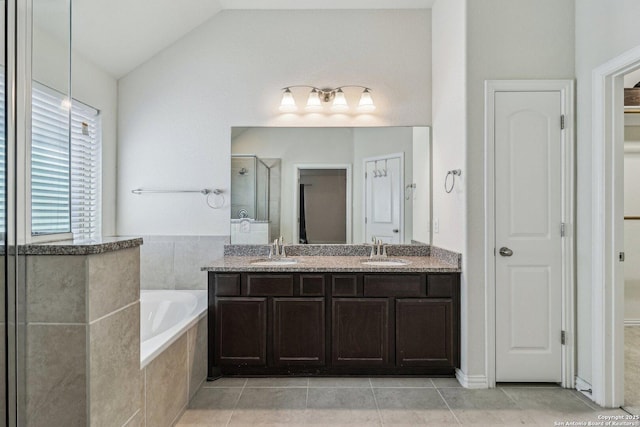 full bath with lofted ceiling, double vanity, a closet, and a sink