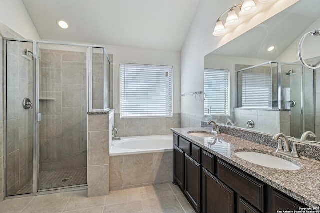 bathroom with vaulted ceiling, tile patterned flooring, a sink, and a bath