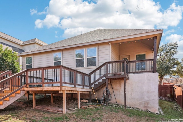 rear view of property featuring stairs, fence, and a deck