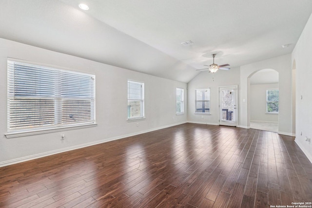 unfurnished living room featuring lofted ceiling, ceiling fan, plenty of natural light, and dark wood finished floors