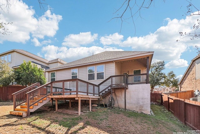 rear view of property with a fenced backyard, a deck, and stairs