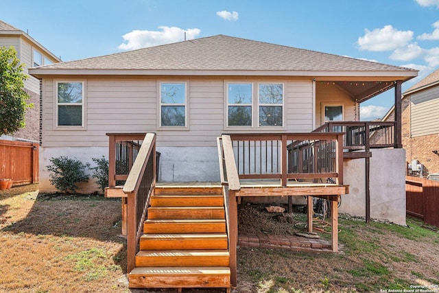 rear view of property with stairs, a deck, a shingled roof, and fence