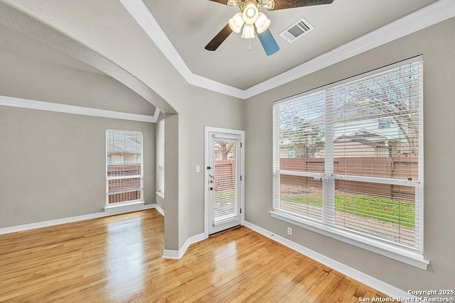 interior space with light wood finished floors, baseboards, visible vents, and ornamental molding