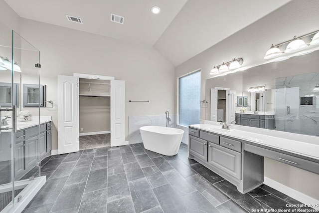 full bath with a stall shower, visible vents, a freestanding bath, and lofted ceiling