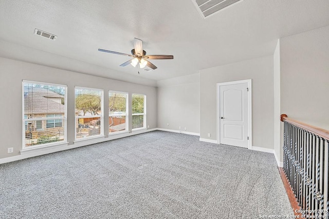 empty room featuring ceiling fan, carpet, visible vents, and baseboards