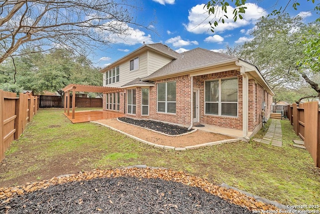 rear view of house featuring brick siding, a patio, a lawn, a pergola, and a fenced backyard