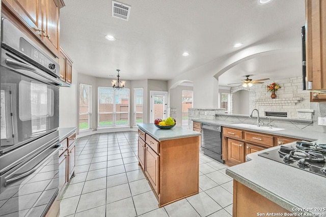 kitchen featuring black appliances, a kitchen island, pendant lighting, and light countertops