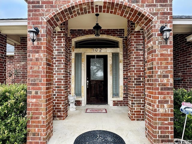 entrance to property featuring brick siding