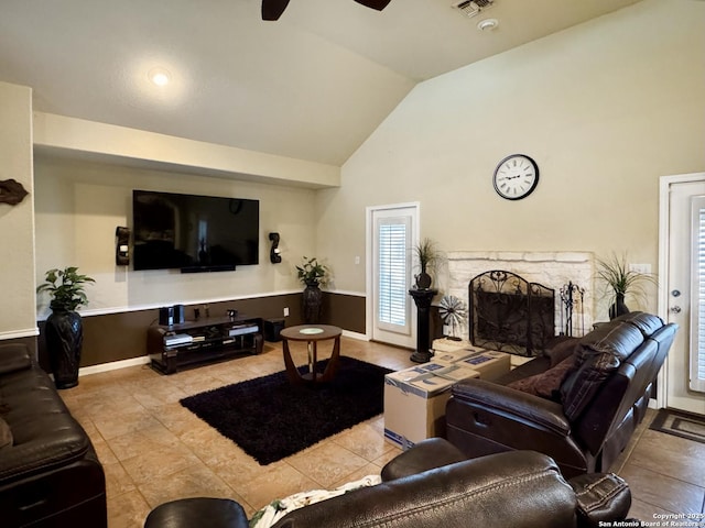 living room with light tile patterned floors, visible vents, ceiling fan, a fireplace, and high vaulted ceiling