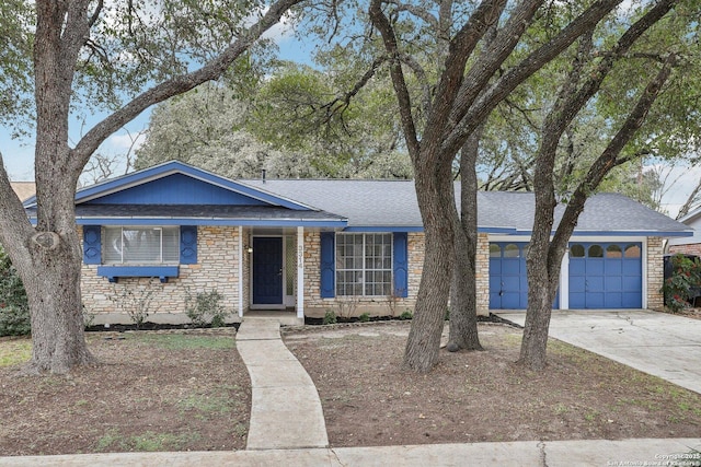 ranch-style house featuring an attached garage, stone siding, driveway, and roof with shingles