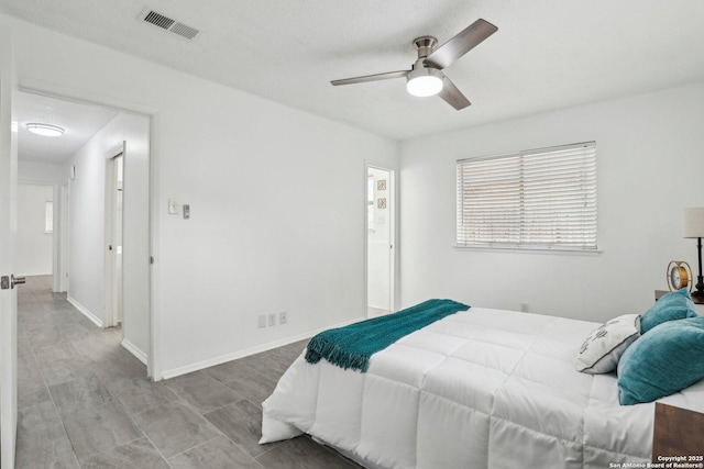 bedroom with a ceiling fan, visible vents, and baseboards