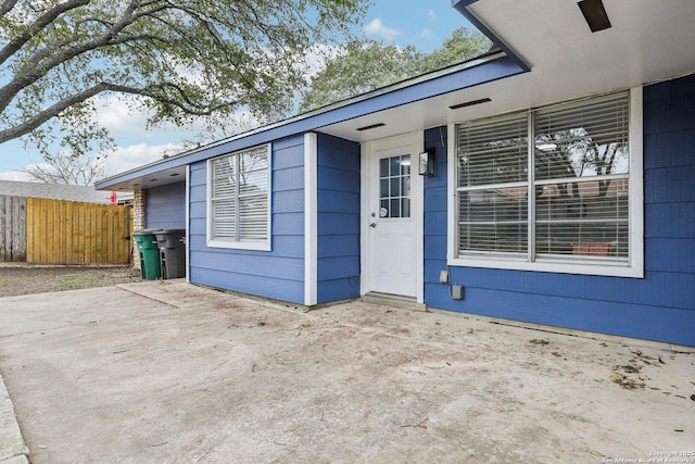 property entrance featuring a patio area and fence