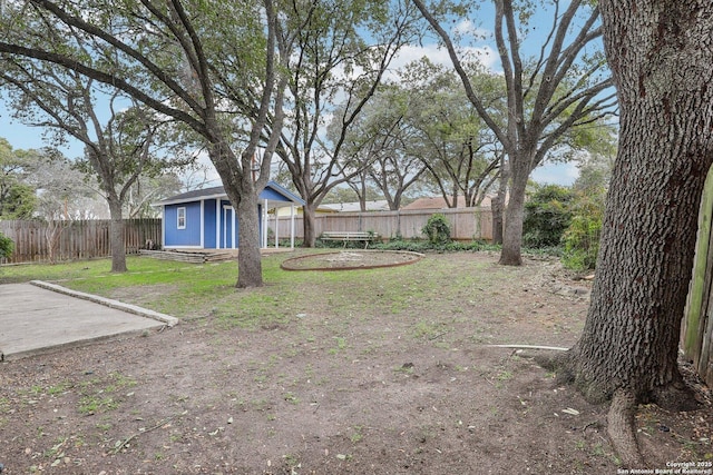 view of yard featuring a fenced backyard, a trampoline, and an outbuilding