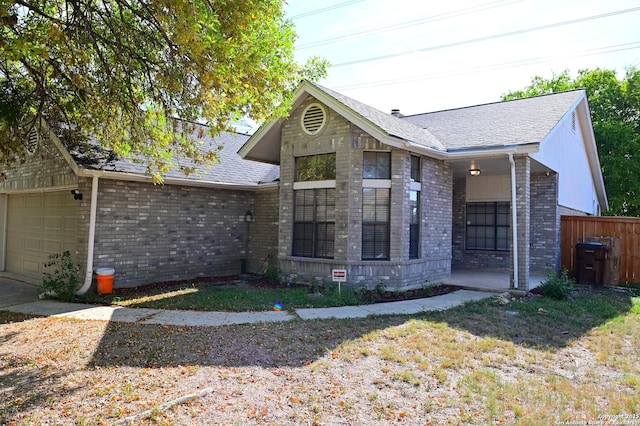 view of front of house featuring a garage, brick siding, fence, and a shingled roof