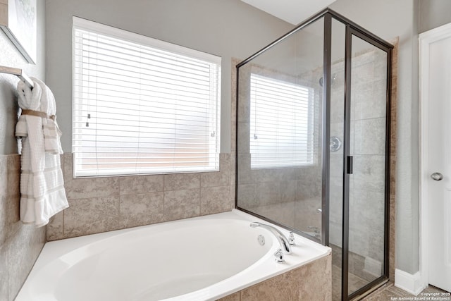 bathroom with a stall shower and a garden tub