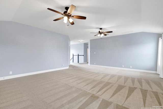 unfurnished room with lofted ceiling, baseboards, and light colored carpet