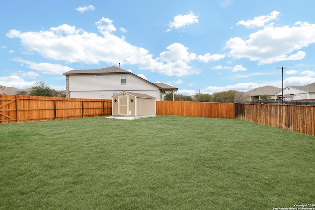 view of yard with a storage unit, an outdoor structure, and a fenced backyard