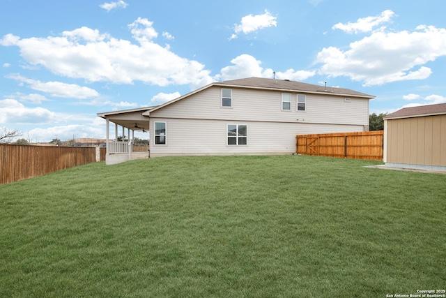 rear view of house featuring a fenced backyard and a yard