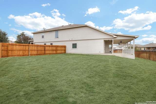 rear view of property with a ceiling fan, a patio area, a lawn, and a fenced backyard