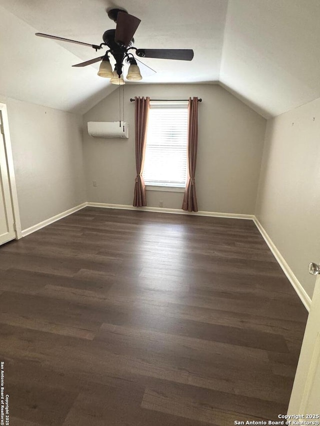 additional living space featuring a wall mounted air conditioner, vaulted ceiling, a ceiling fan, and baseboards