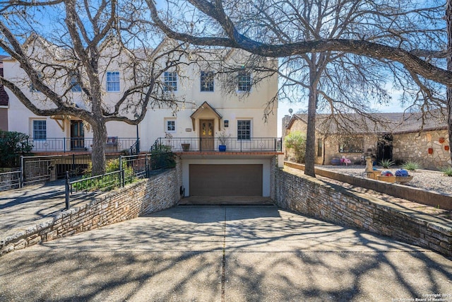 view of front of home with a garage, fence, concrete driveway, and stucco siding