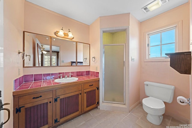 full bath featuring toilet, vanity, visible vents, baseboards, and a shower stall