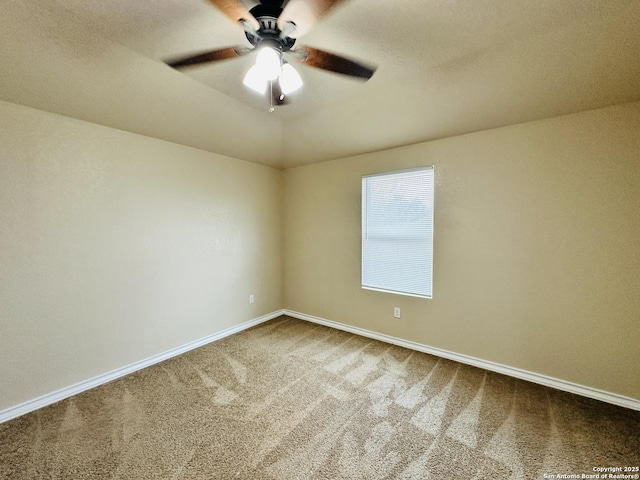 carpeted empty room with a ceiling fan and baseboards