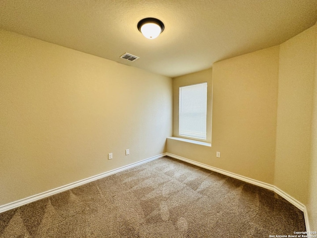 unfurnished room with baseboards, visible vents, and carpet flooring