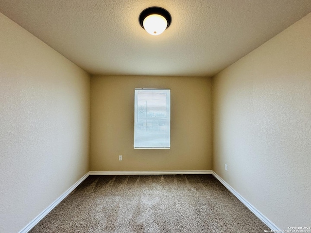 unfurnished room featuring carpet, a textured wall, a textured ceiling, and baseboards