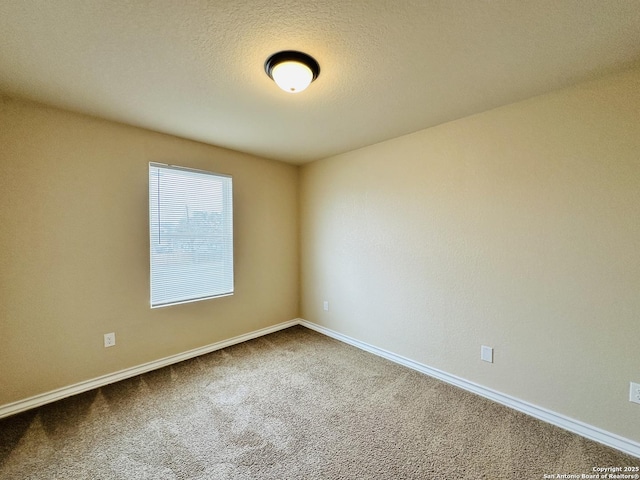 carpeted spare room with baseboards and a textured ceiling