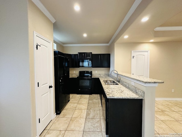 kitchen featuring light stone counters, a sink, dark cabinetry, a peninsula, and black appliances