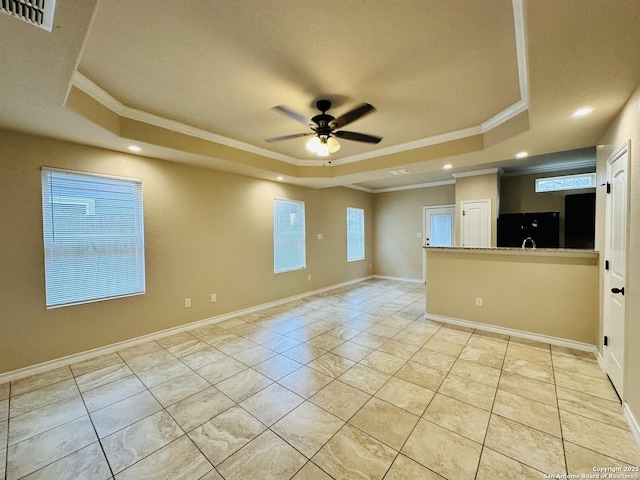 empty room featuring ornamental molding, a tray ceiling, and a ceiling fan