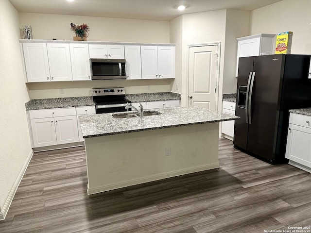 kitchen featuring stainless steel appliances, a kitchen island with sink, and white cabinetry