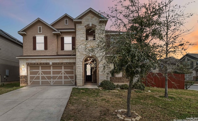 view of front facade with a garage, driveway, stone siding, and a front yard