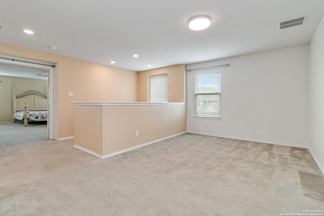 empty room with light carpet, baseboards, visible vents, and recessed lighting