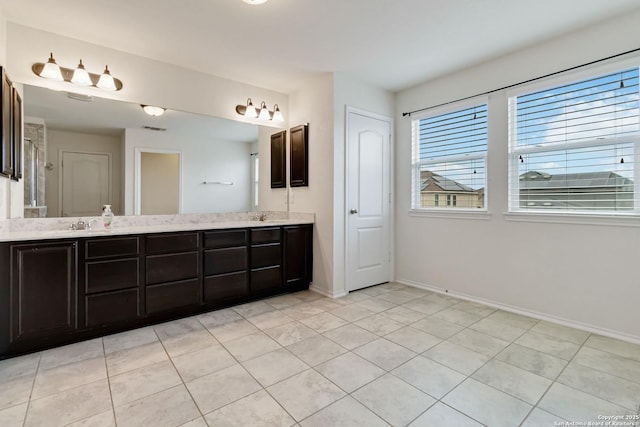 bathroom with double vanity, visible vents, baseboards, tile patterned flooring, and a sink