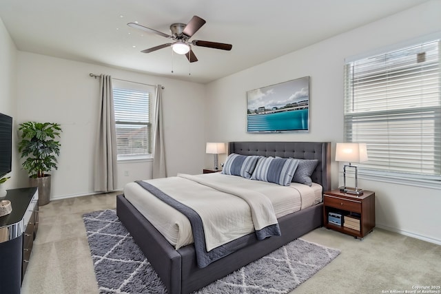 bedroom featuring baseboards, a ceiling fan, and light colored carpet