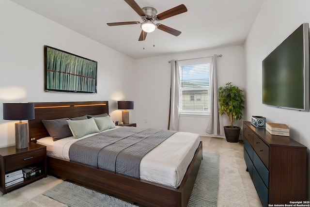 bedroom with a ceiling fan and light carpet