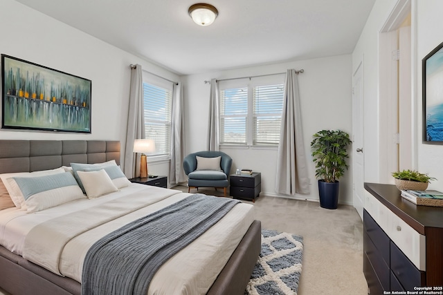 bedroom with light carpet and baseboards