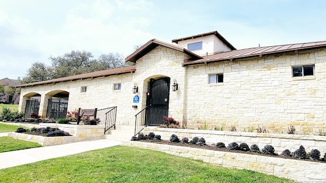 view of front of property featuring a standing seam roof, metal roof, and a front yard