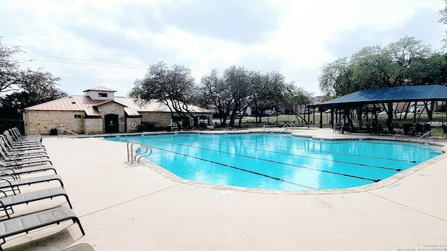 pool with a patio, a gazebo, and fence