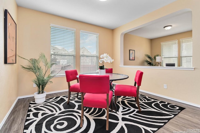 dining area with plenty of natural light, wood finished floors, and baseboards