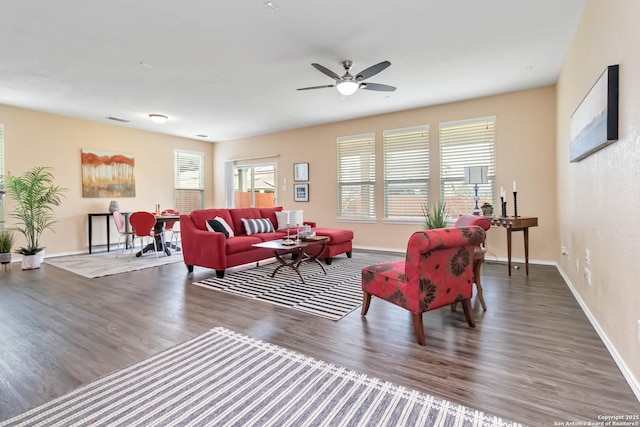 living area with dark wood-style floors, visible vents, baseboards, and a ceiling fan