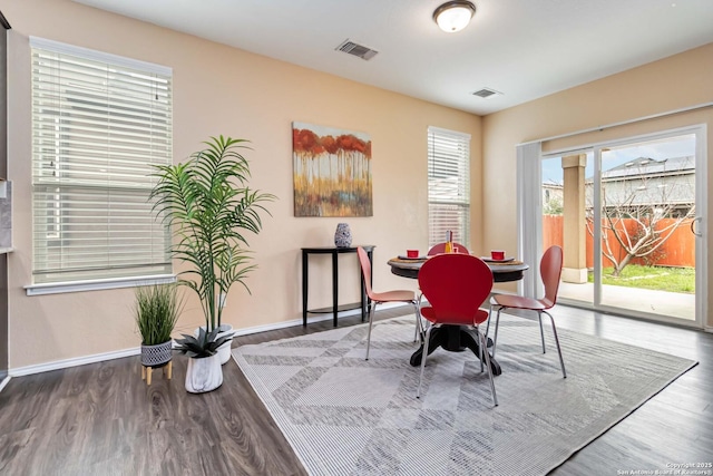 dining room featuring visible vents, baseboards, and wood finished floors