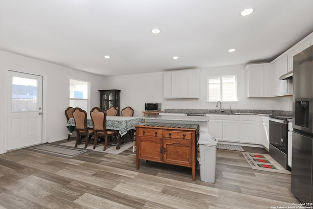 kitchen with under cabinet range hood, appliances with stainless steel finishes, white cabinets, and recessed lighting