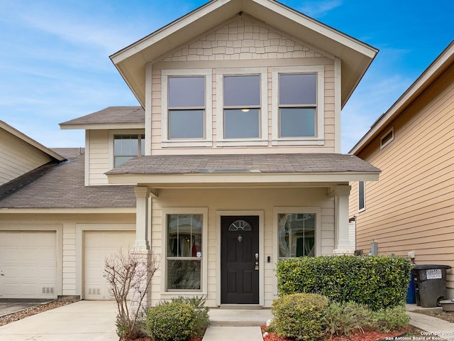 view of front of home with driveway, a shingled roof, and an attached garage